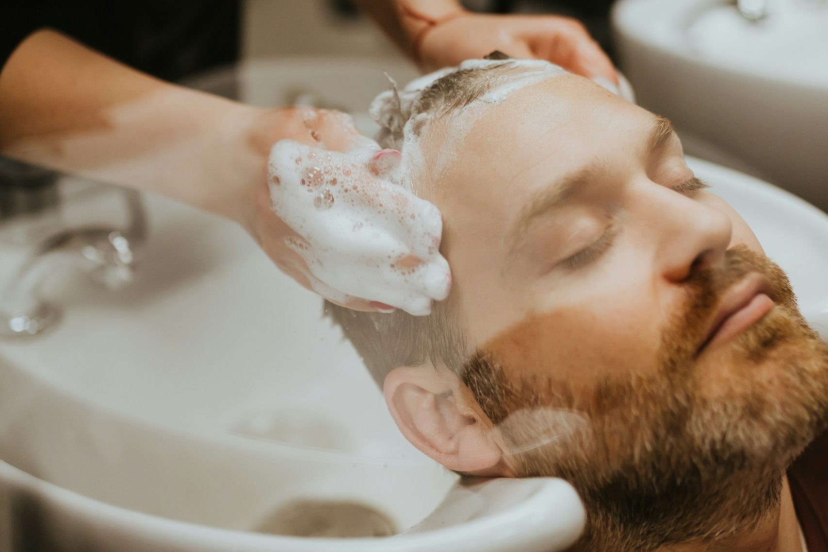 Einem Mann werden die Haare gewaschen